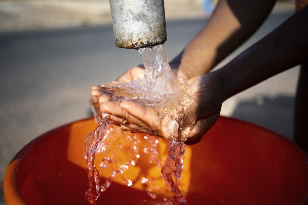 Analisi acqua pozzo, immagine di una persona che raccoglie acqua con le mani