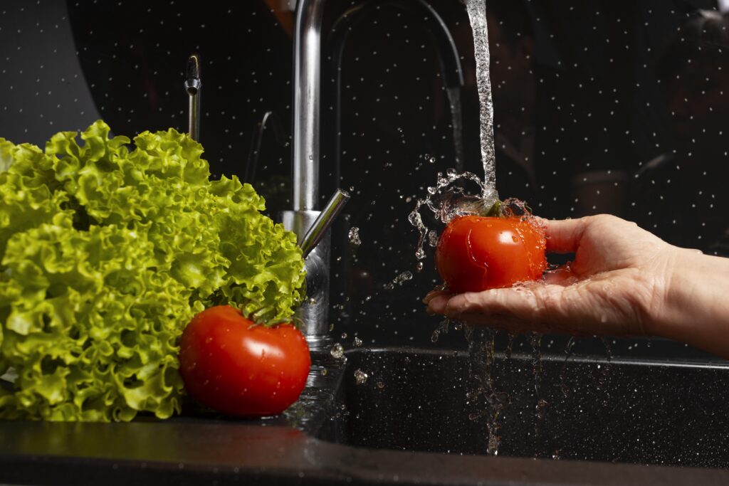 Analisi acqua di rubinetto: immagine di una pwersona che lava le verdure