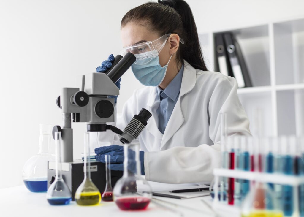 Analisi microbiologiche degli alimenti, immagine di una professionista al microscopio